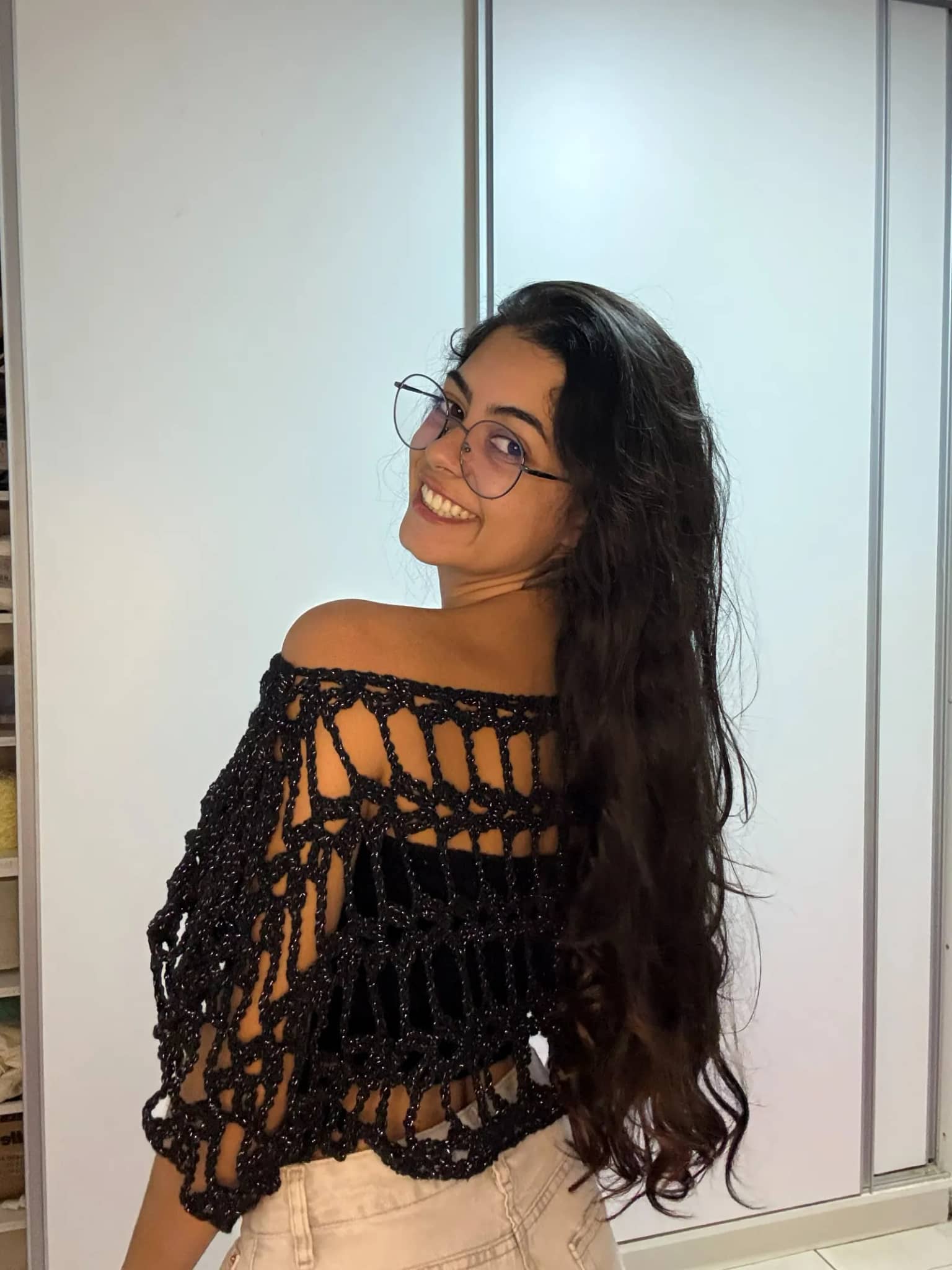 Costas da bata de crochê preta de trama aberta