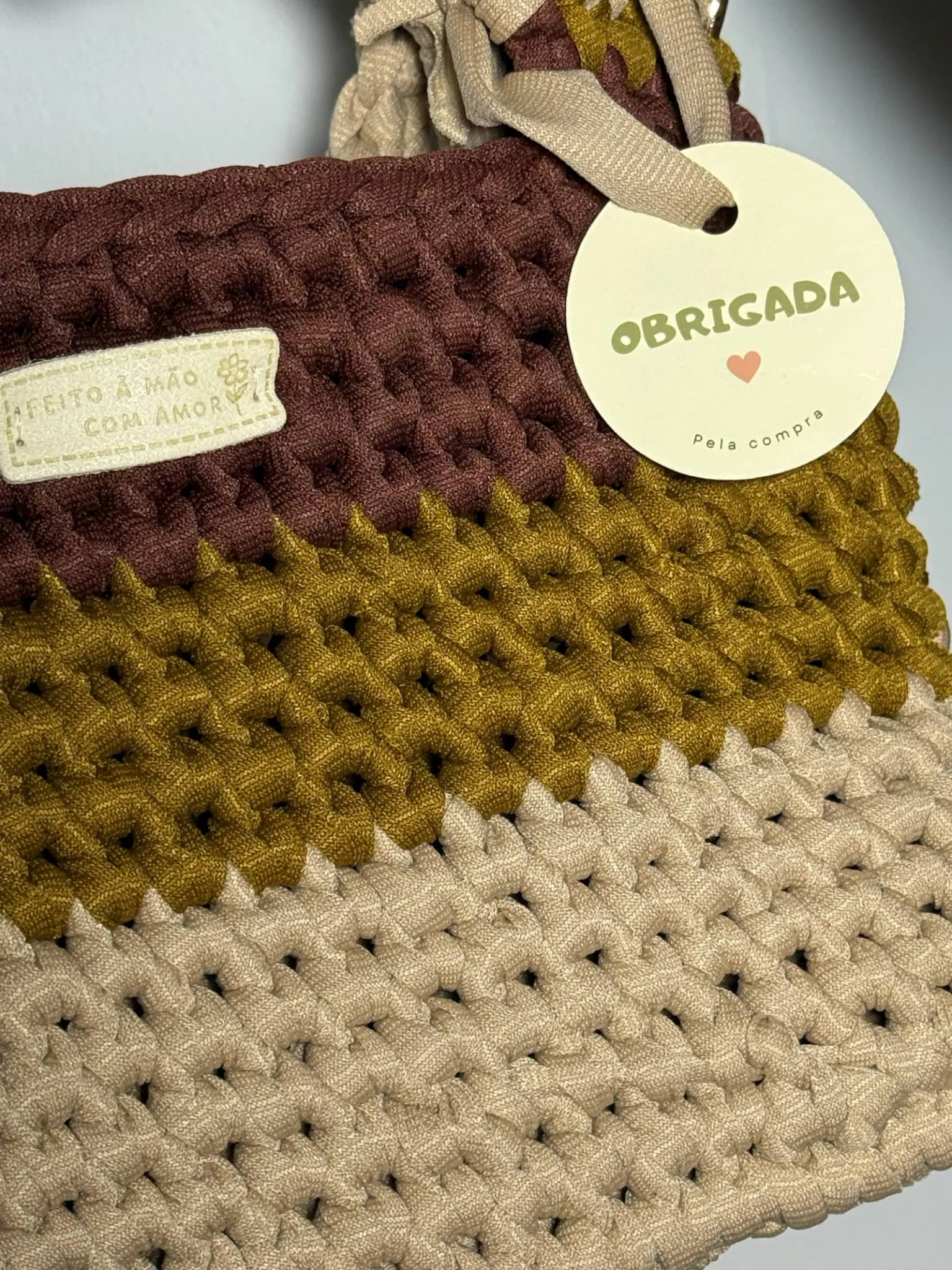 Ponto firme da bolsa de três cores, de perto, com a tag de agradecimento