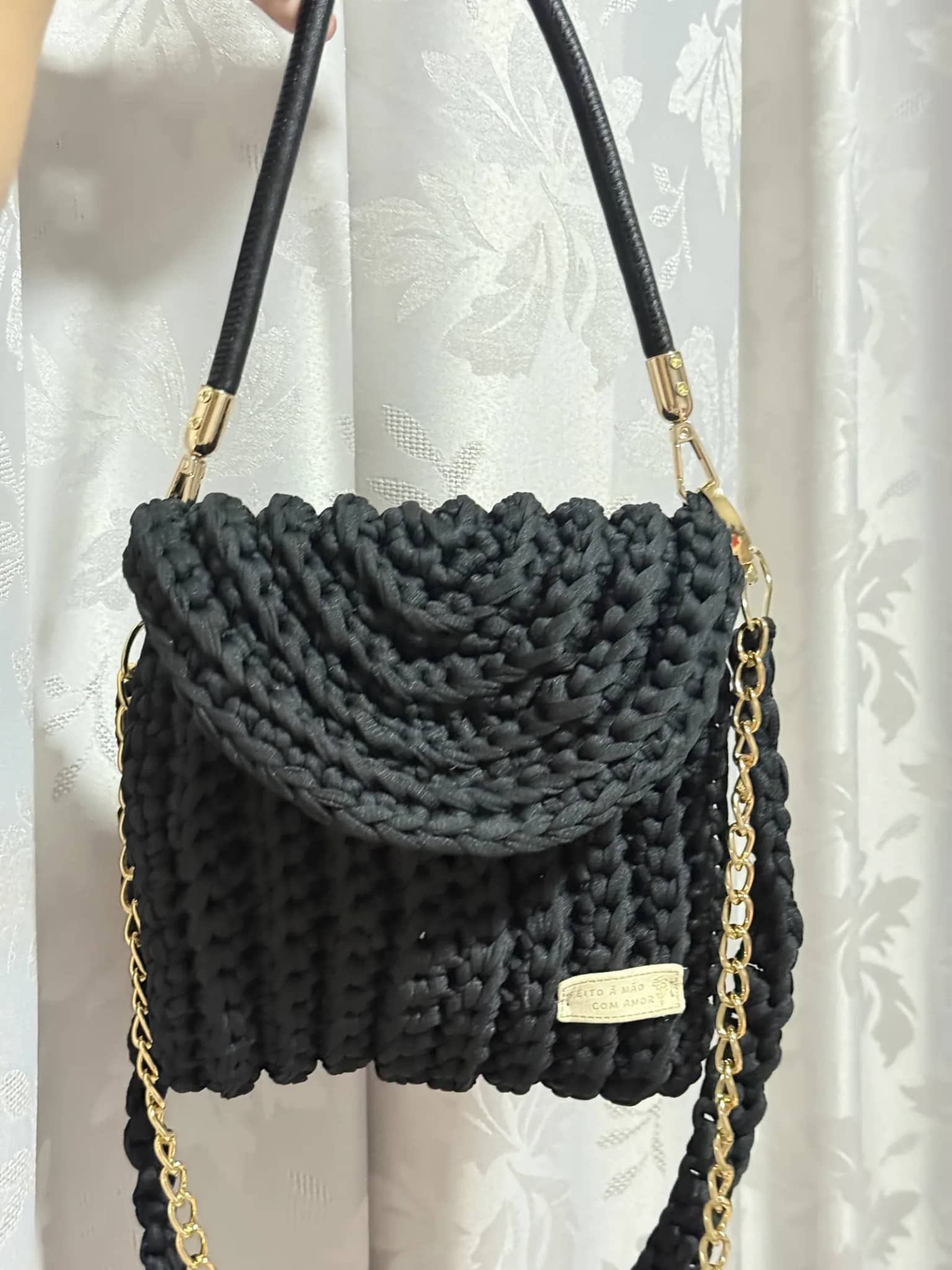 Bolsa preta com aba, alça rígida e corrente