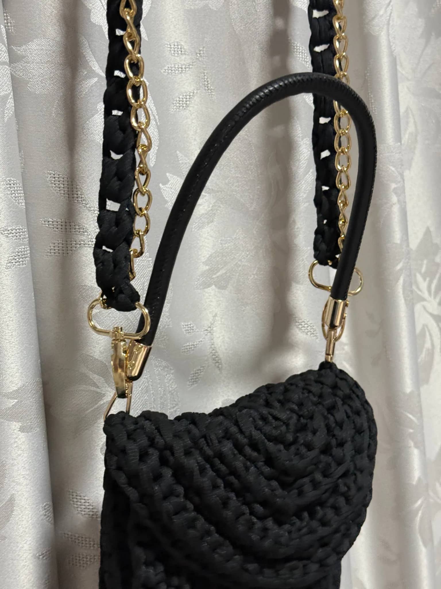 Detalhe da aba em relevo da bolsa preta