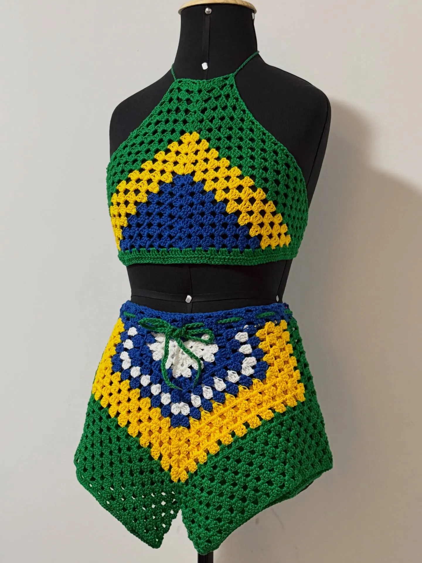 Conjunto de crochê granny square verde, amarelo e azul: top halter e saia, no manequim