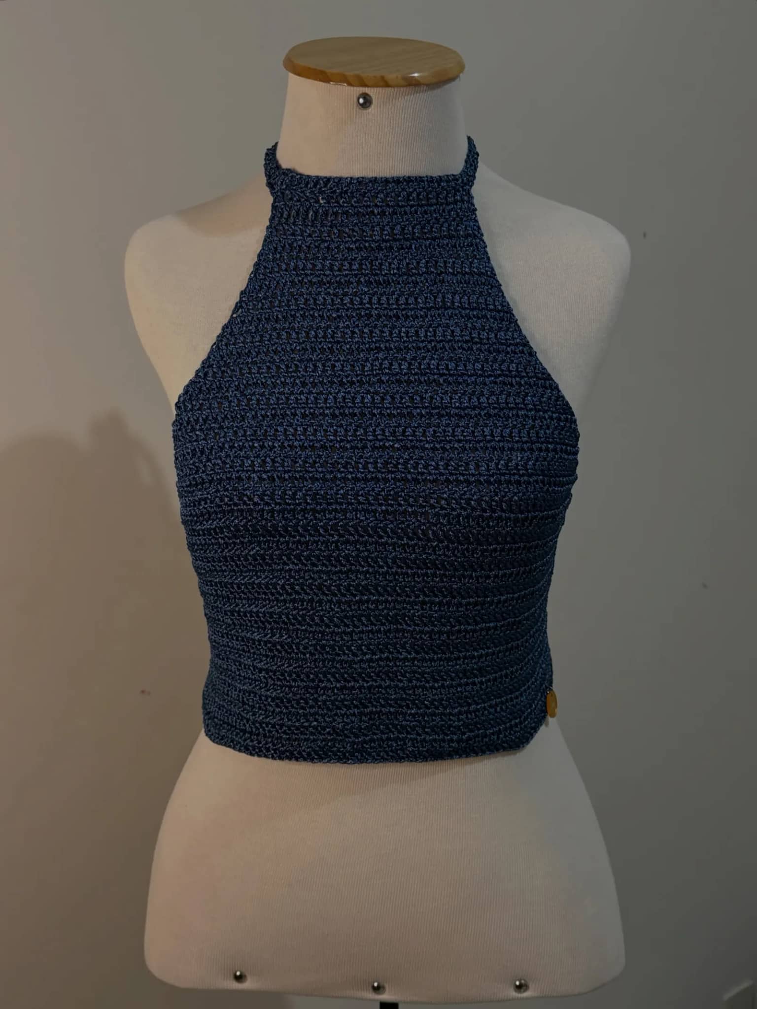 Cropped de crochê azul-marinho de gola alta, no manequim