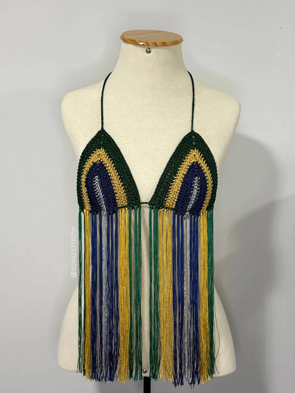 Cropped Torcedor de crochê verde, dourado, azul e prata com franjas longas, no manequim