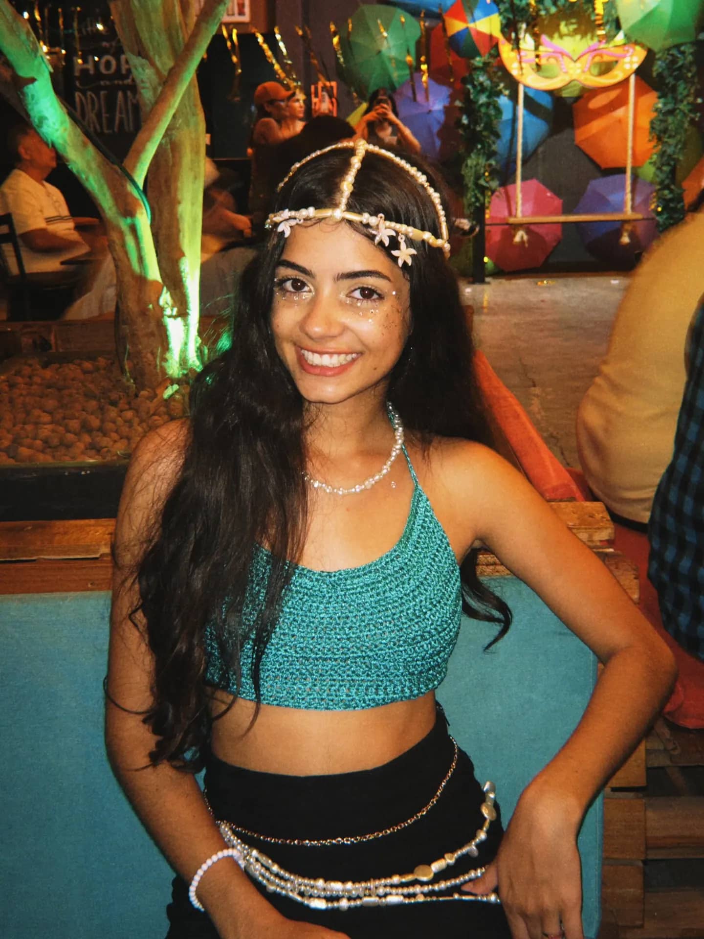 Cliente sorrindo usando cropped de crochê turquesa
