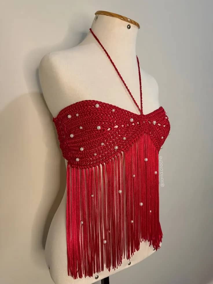Cropped de crochê vermelho com pérolas e franjas longas, no manequim