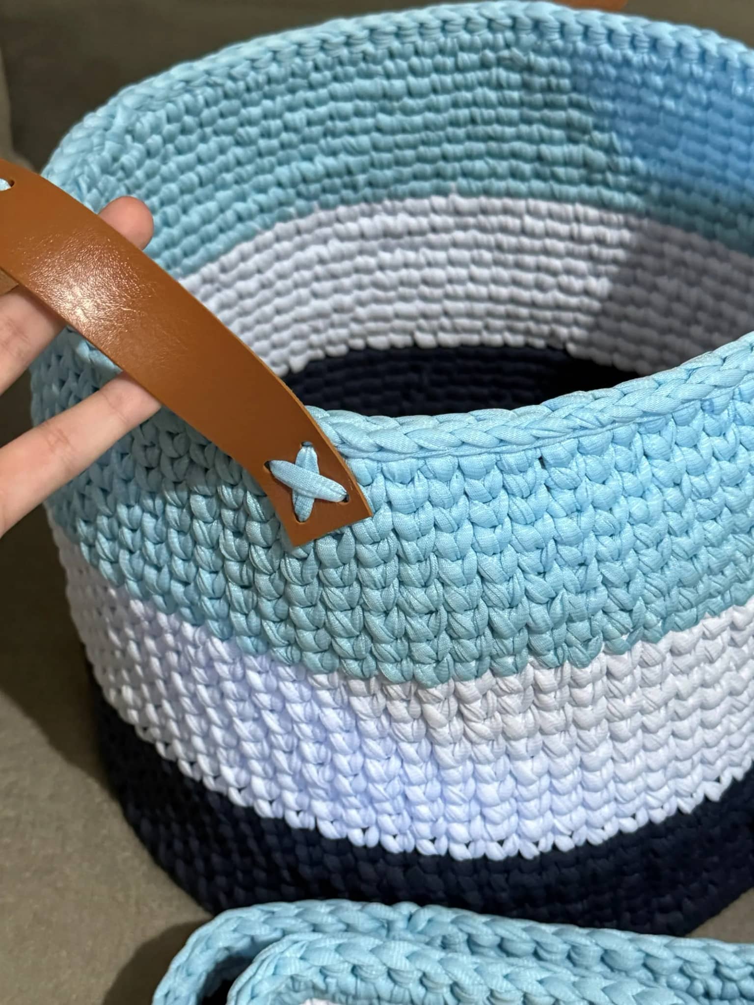 Detalhe da alça de couro costurada no cesto de crochê
