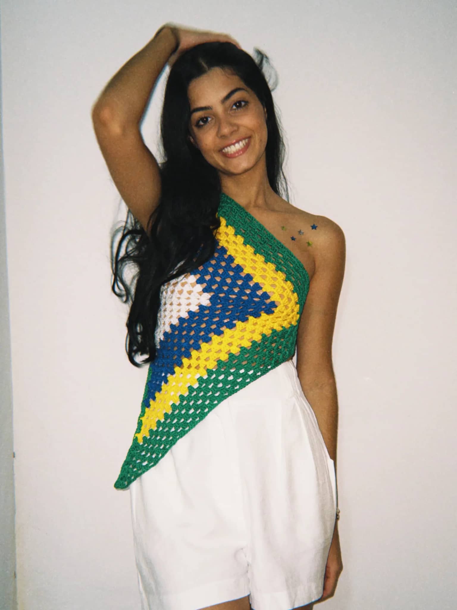 Cropped de crochê granny square nas cores do Brasil, em modelo halter, usado por cliente