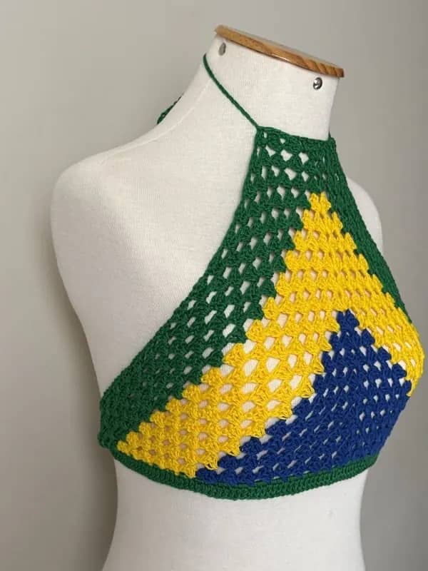 Cropped trapézio de crochê verde, amarelo e azul visto de lado