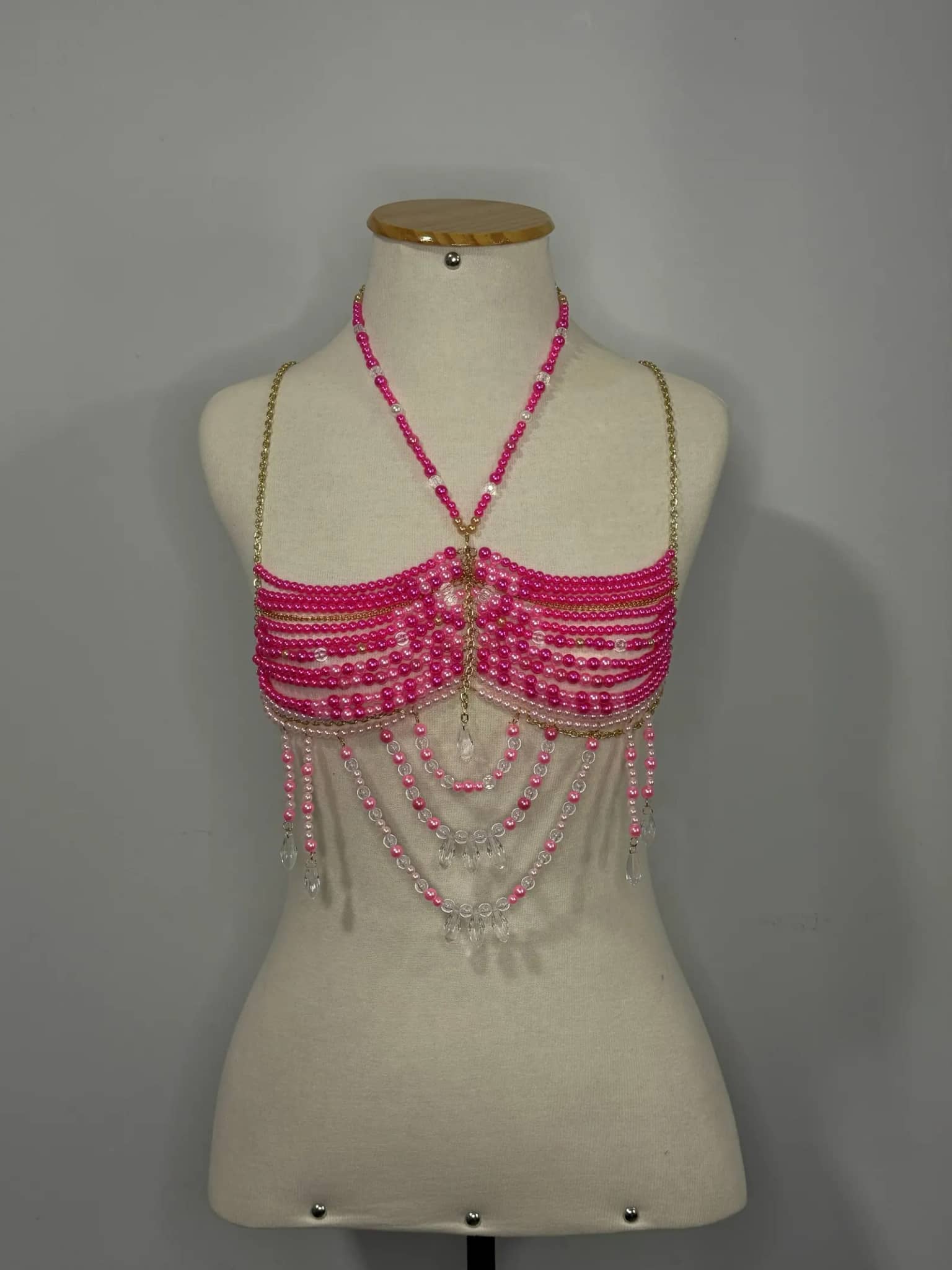 Top de miçangas pink com correntinha dourada e pingentes de cristal, no manequim