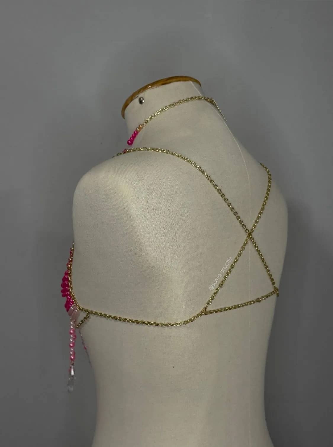 Costas do top de miçangas pink, com correntinha dourada cruzada