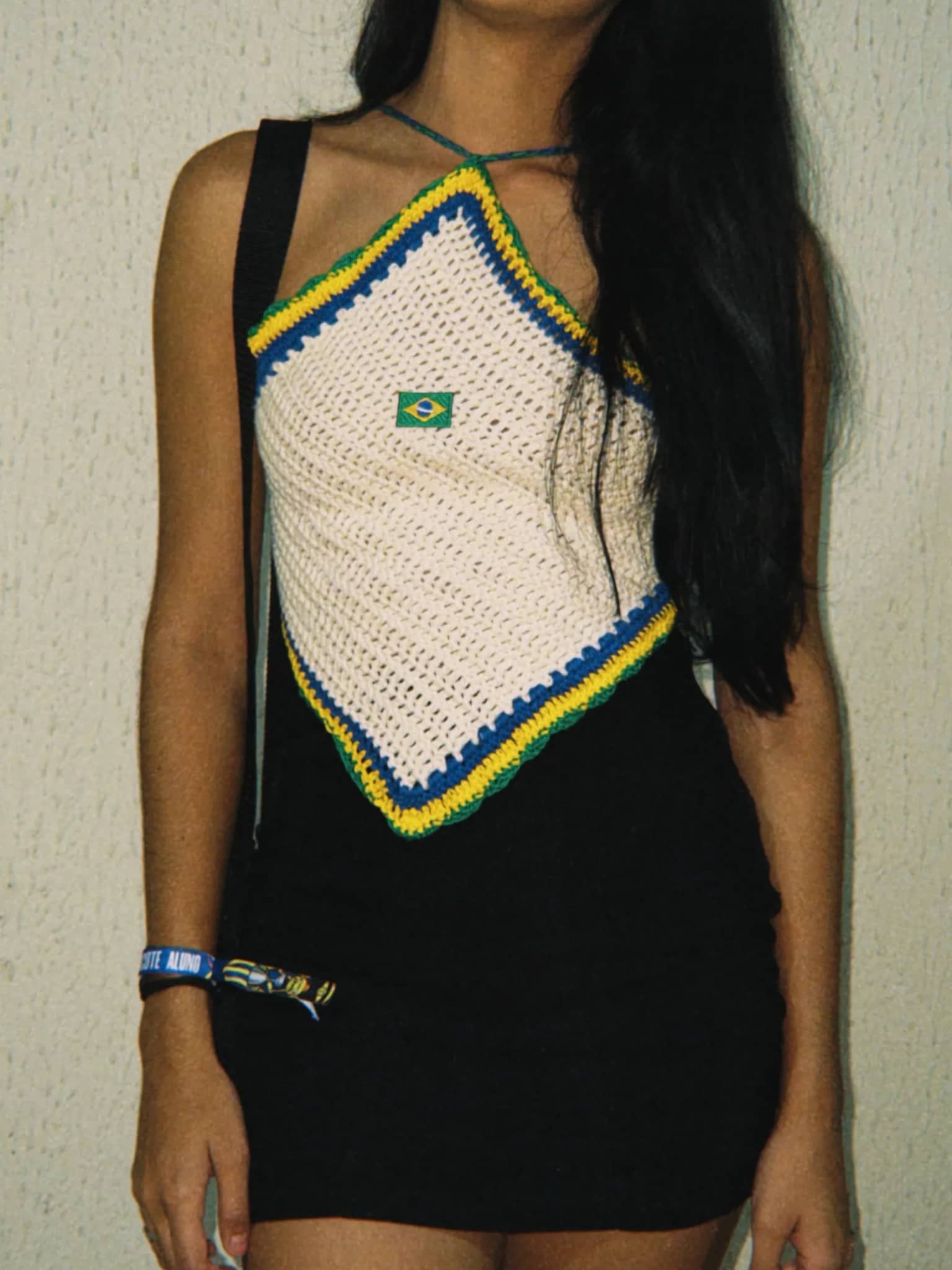 Cropped triangular de crochê off-white com borda verde, azul e amarela, usado por cliente